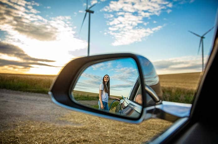 Frau mit E-Auto auf Feld