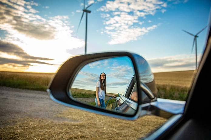 Frau mit E-Auto afu Feld